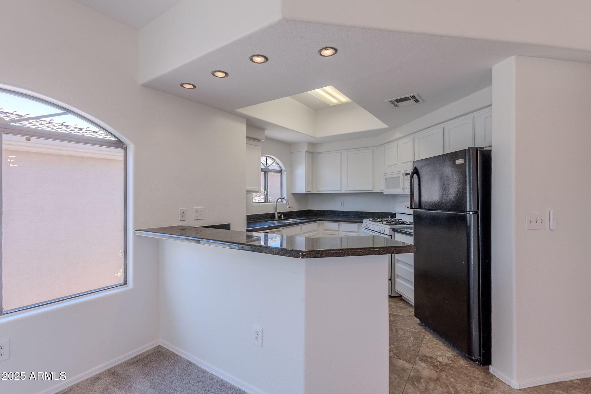 10030 West Indian School Road, Unit 218 Phoenix, AZ 85037 - Photo 2 of 28 a kitchen with stainless steel appliances granite countertop a refrigerator and a sink