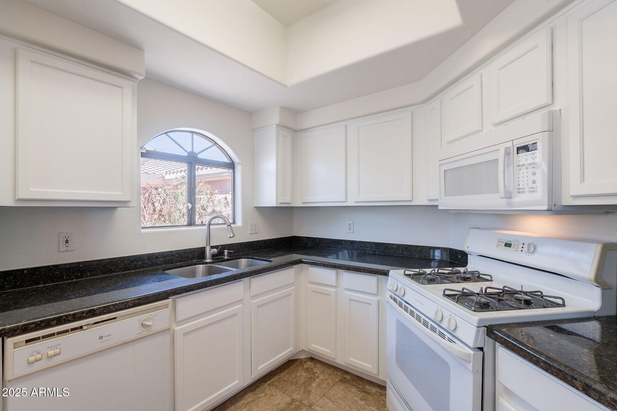 10030 West Indian School Road, Unit 218 Phoenix, AZ 85037 - Photo 3 of 28 a kitchen with granite countertop white cabinets and appliances