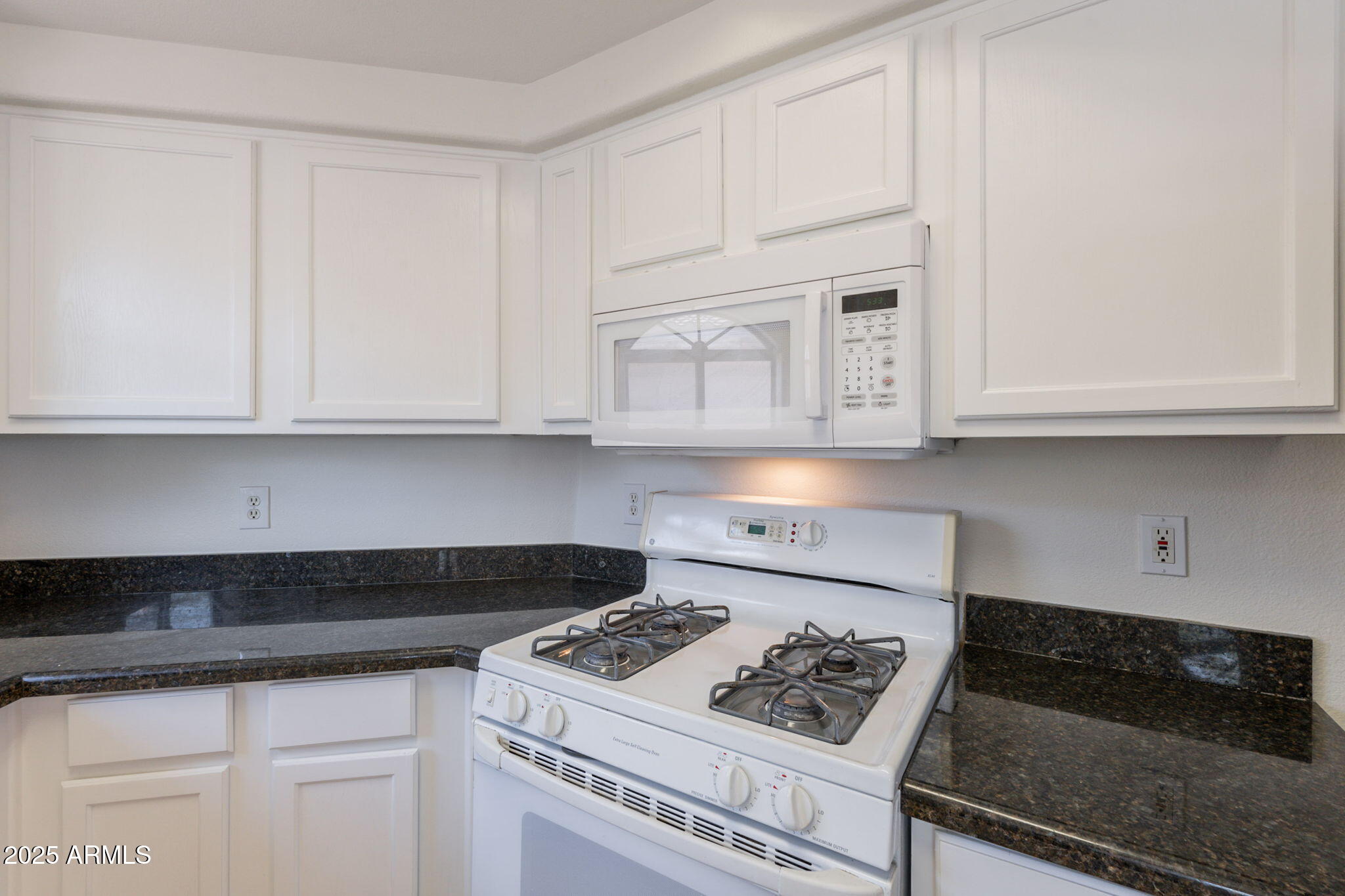 10030 West Indian School Road, Unit 218 Phoenix, AZ 85037 - Photo 4 of 28 a kitchen with white cabinets and appliances