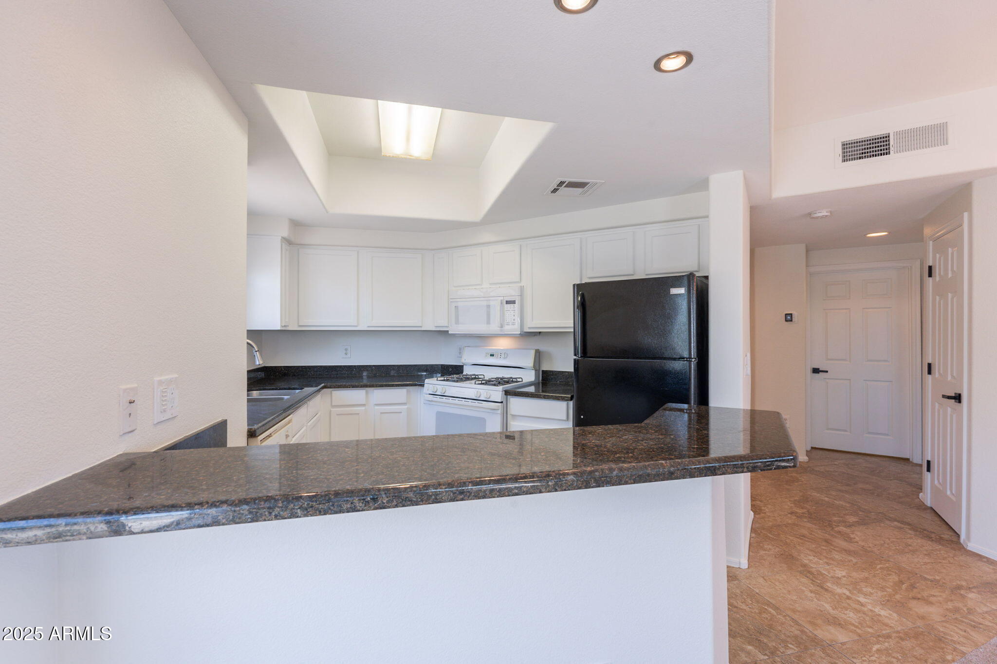10030 West Indian School Road, Unit 218 Phoenix, AZ 85037 - Photo 6 of 28 a kitchen with granite countertop a sink and a stove top oven