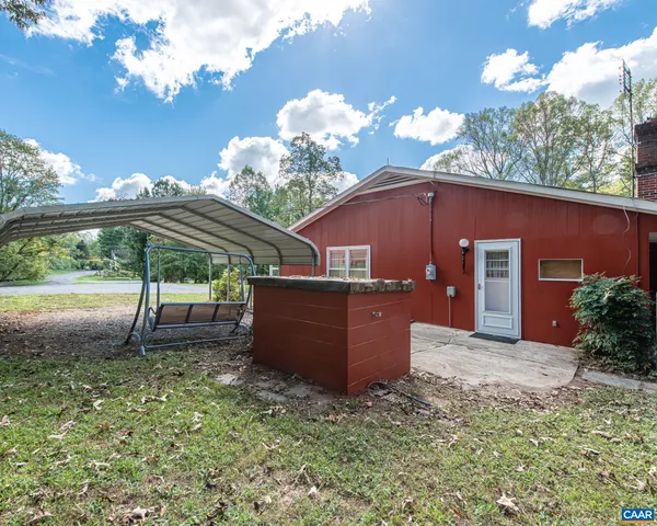 a view of swimming pool with lawn chairs and iron fence