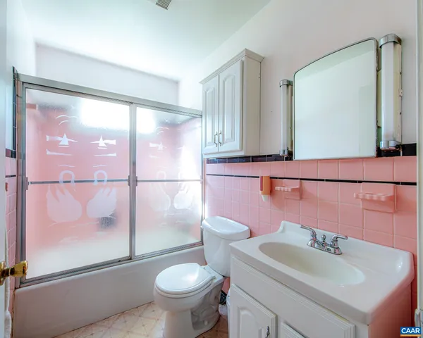 a view of a livingroom with wooden floor a ceiling fan and windows