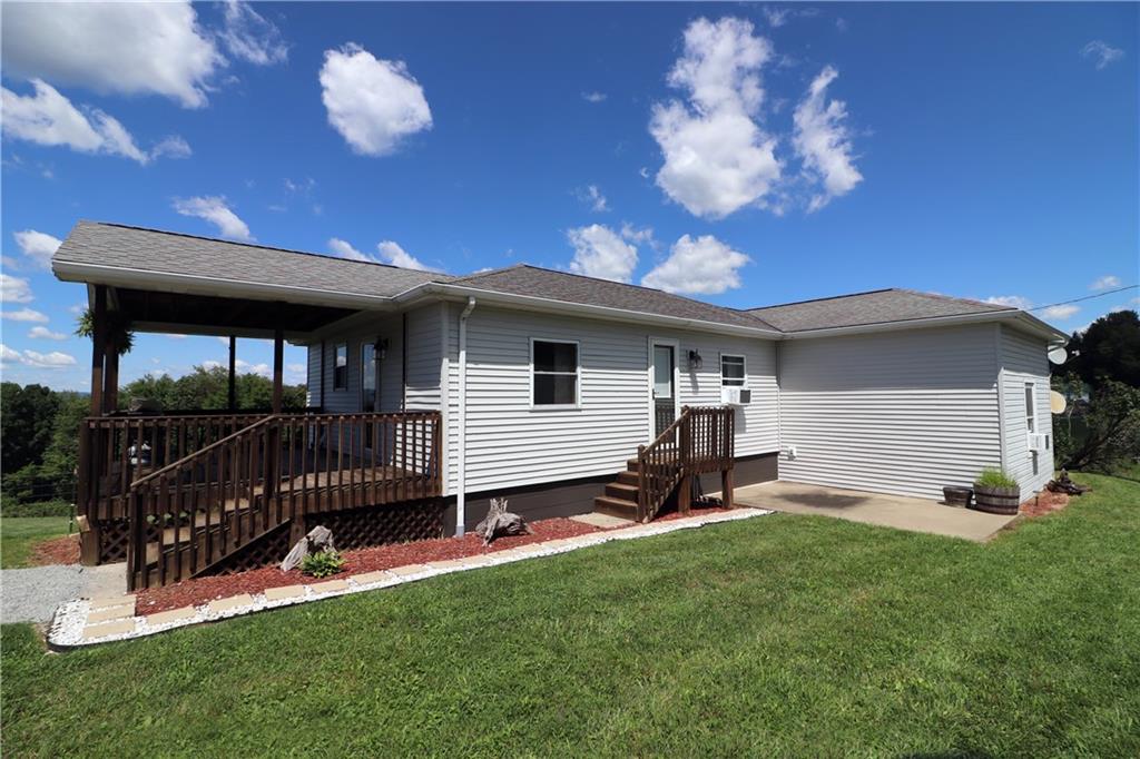 a view of a house with backyard and a tree