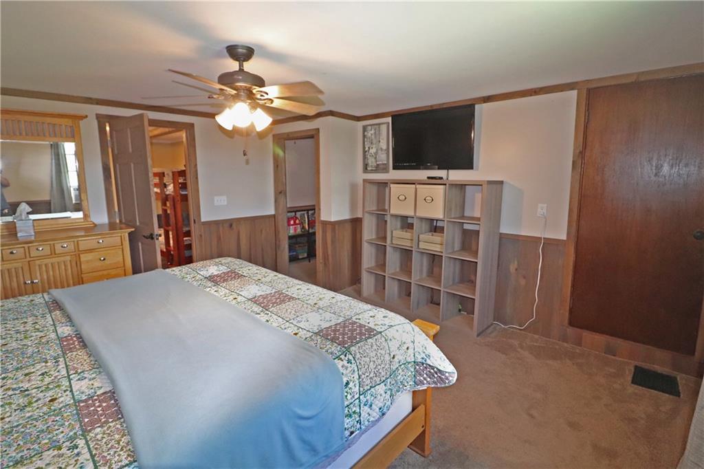 2 Miller Road Mill Run, PA 15464 - Photo 15 of 21 a bedroom with a large bed and a flat tv screen