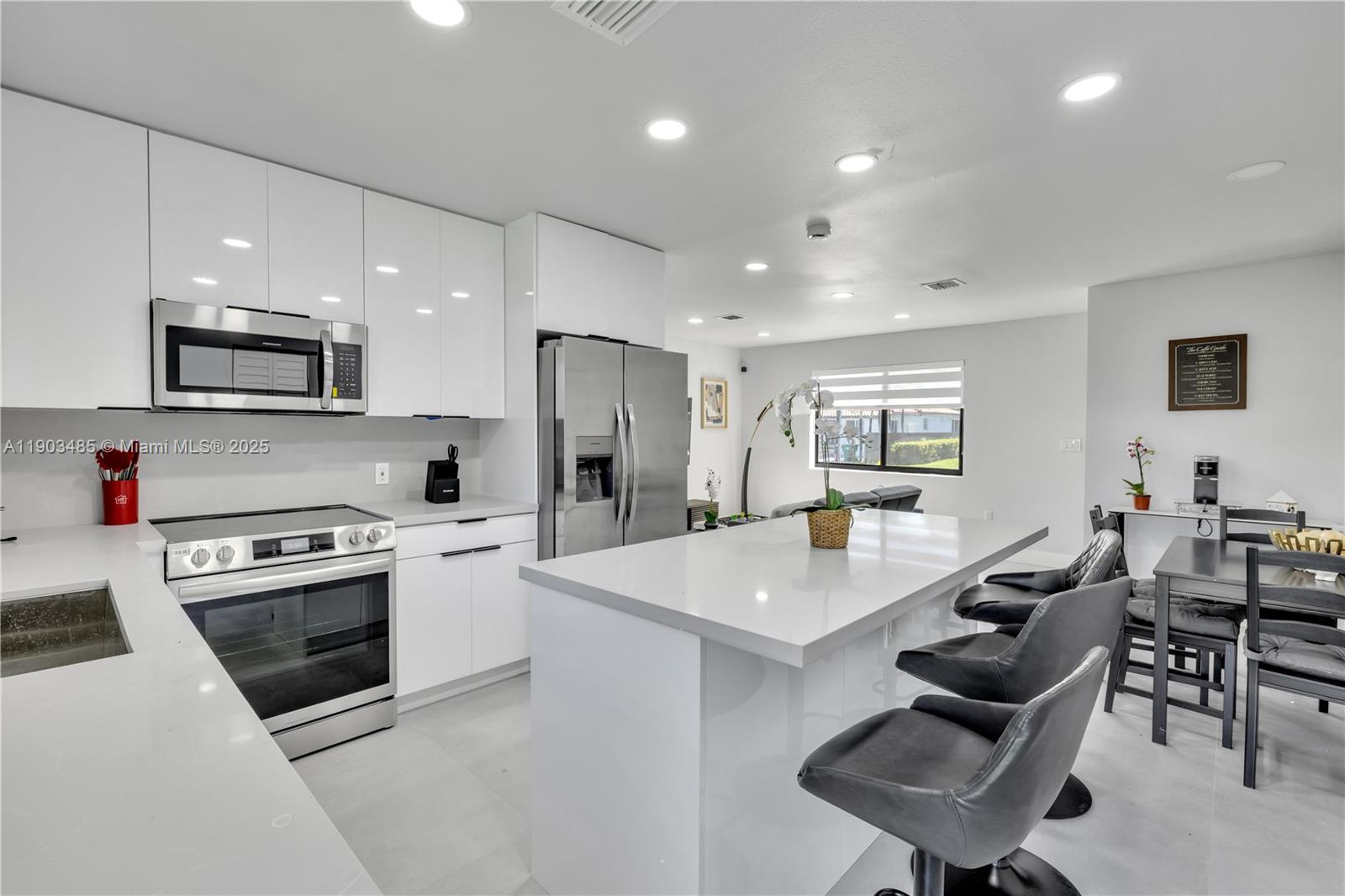 6021 Southwest 19th Street Miami, FL 33155 - Photo 3 of 20 a open kitchen with stainless steel appliances kitchen island granite countertop a stove a sink a dining table and chairs