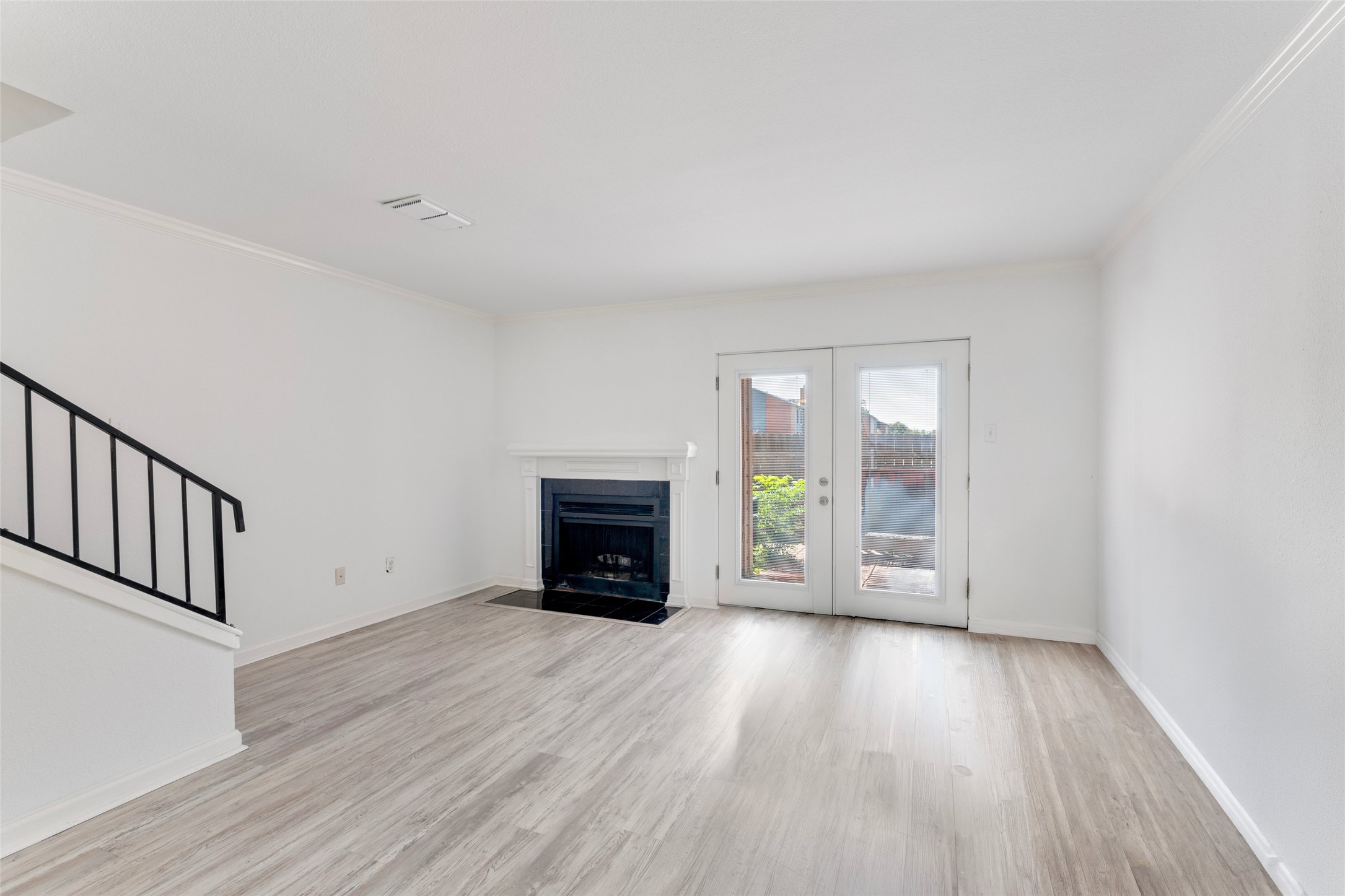 2018 West Rundberg Lane, Unit 16D Austin, TX 78758 - Photo 3 of 18 A welcoming living space features a fireplace, light flooring, and glass doors opening to back deck.