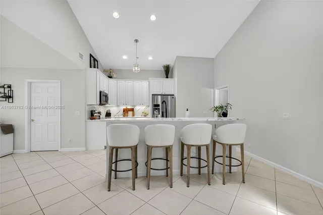 a spacious bedroom with a bed and a chandelier