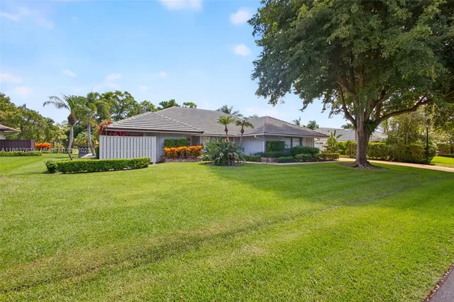 a front view of a house with a yard and potted plants