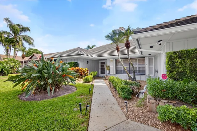 a front view of a house with a yard and potted plants
