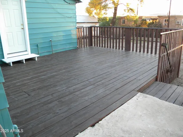 a view of a small house with wooden fence