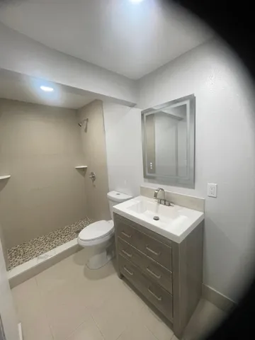 a bathroom with a sink a toilet and a mirror