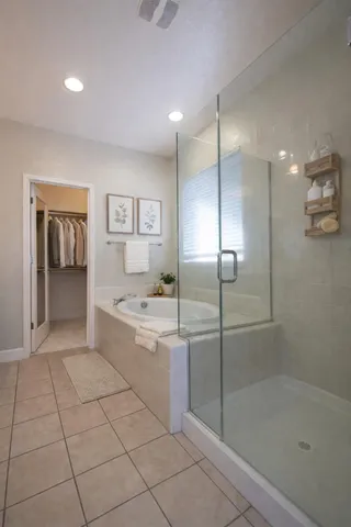 a spacious bathroom with a shower a mirror and a shower