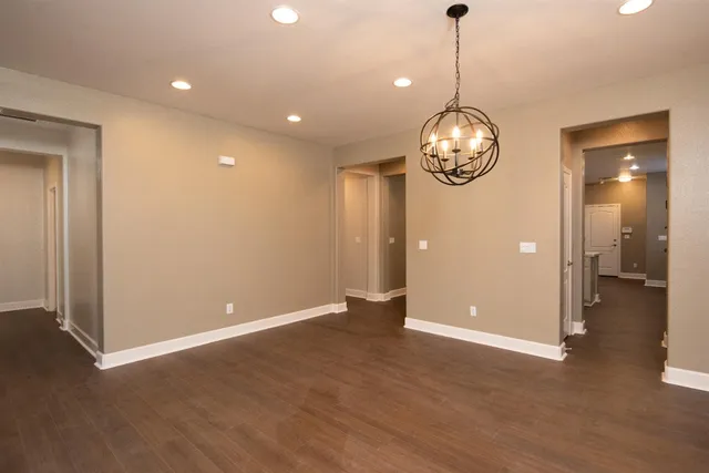 an empty room with wooden floor and mirror