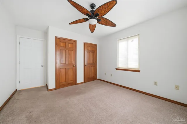 an empty room with closet and windows
