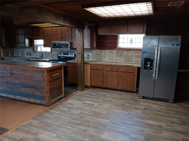 a kitchen with stainless steel appliances granite countertop a stove a sink and a refrigerator