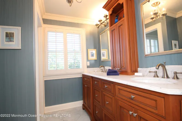 a bathroom with a granite countertop sink and a window
