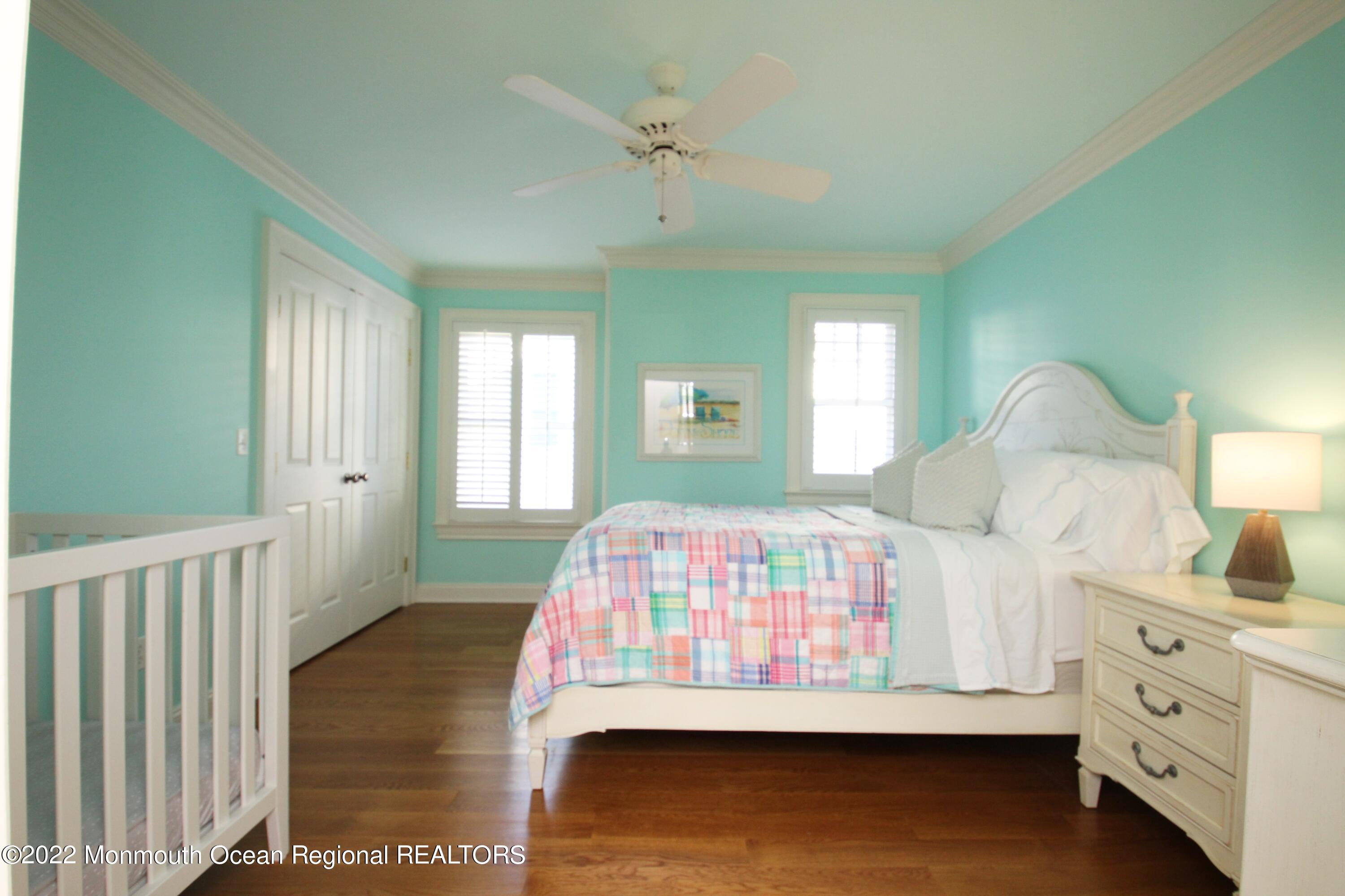 106 Stockton Boulevard Sea Girt, NJ 08750 - Photo 15 of 27 a bedroom with a large bed and a chandelier