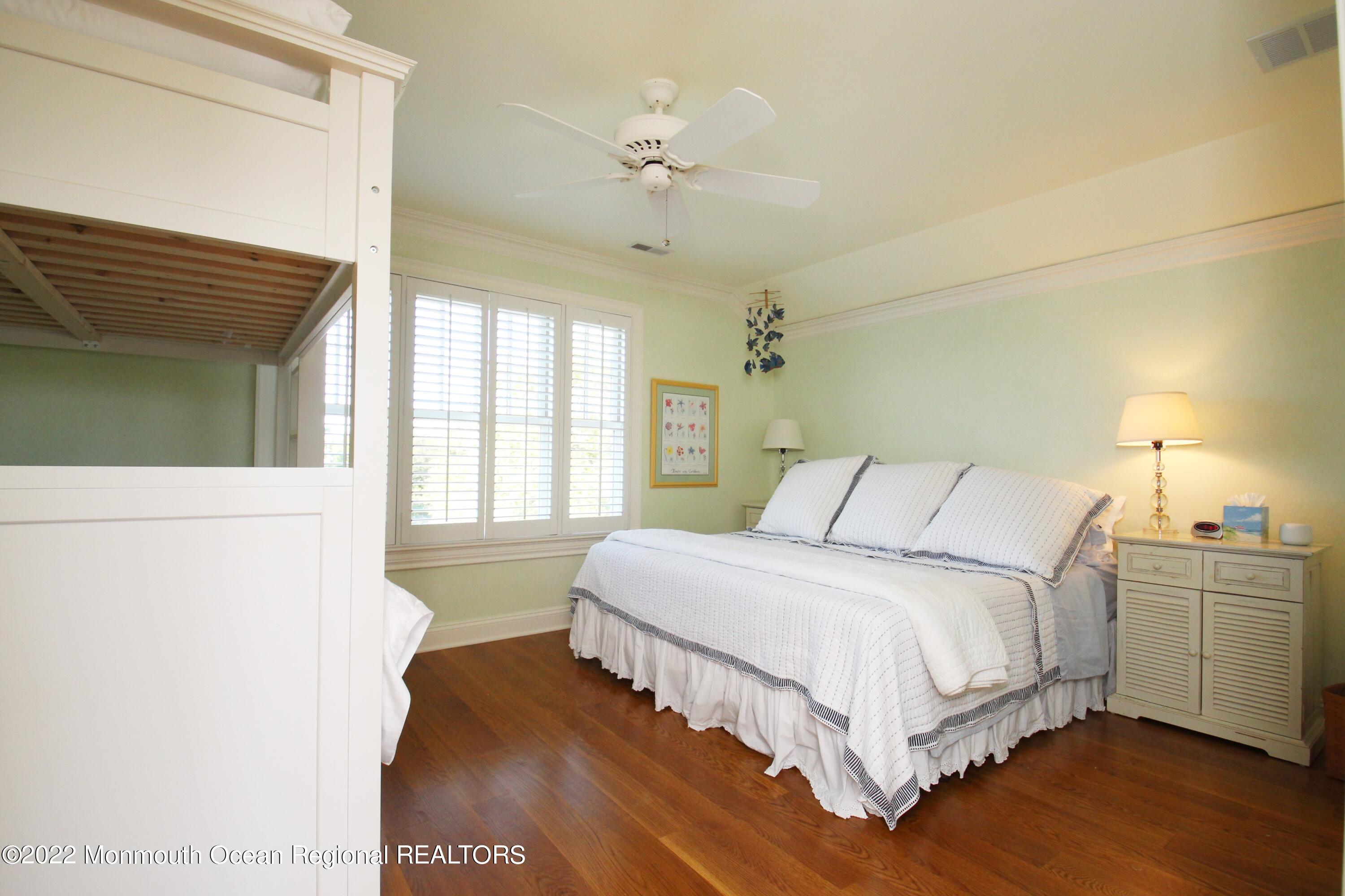 106 Stockton Boulevard Sea Girt, NJ 08750 - Photo 21 of 27 a bedroom with a large bed and a chandelier