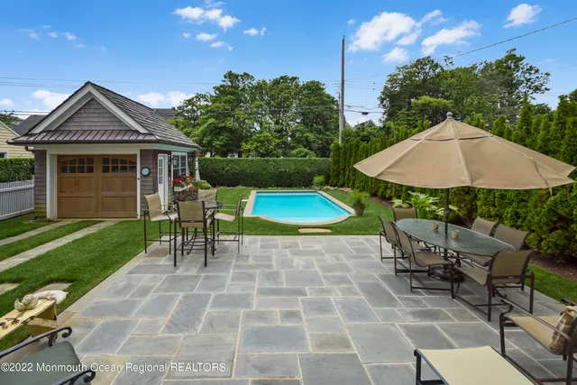 a view of a patio with a table and chairs under an umbrella