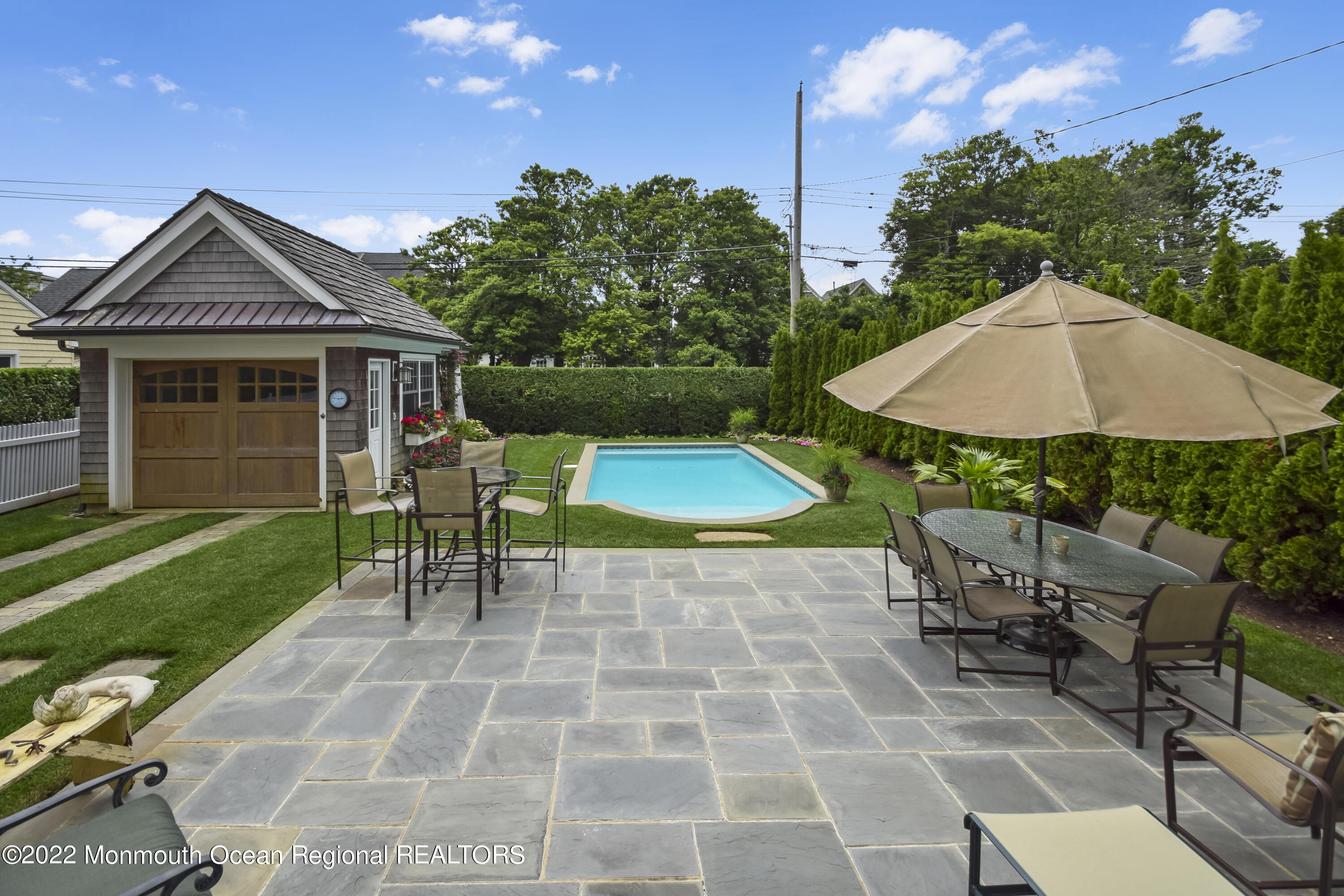 106 Stockton Boulevard Sea Girt, NJ 08750 - Photo 25 of 27 a view of a patio with a table and chairs under an umbrella