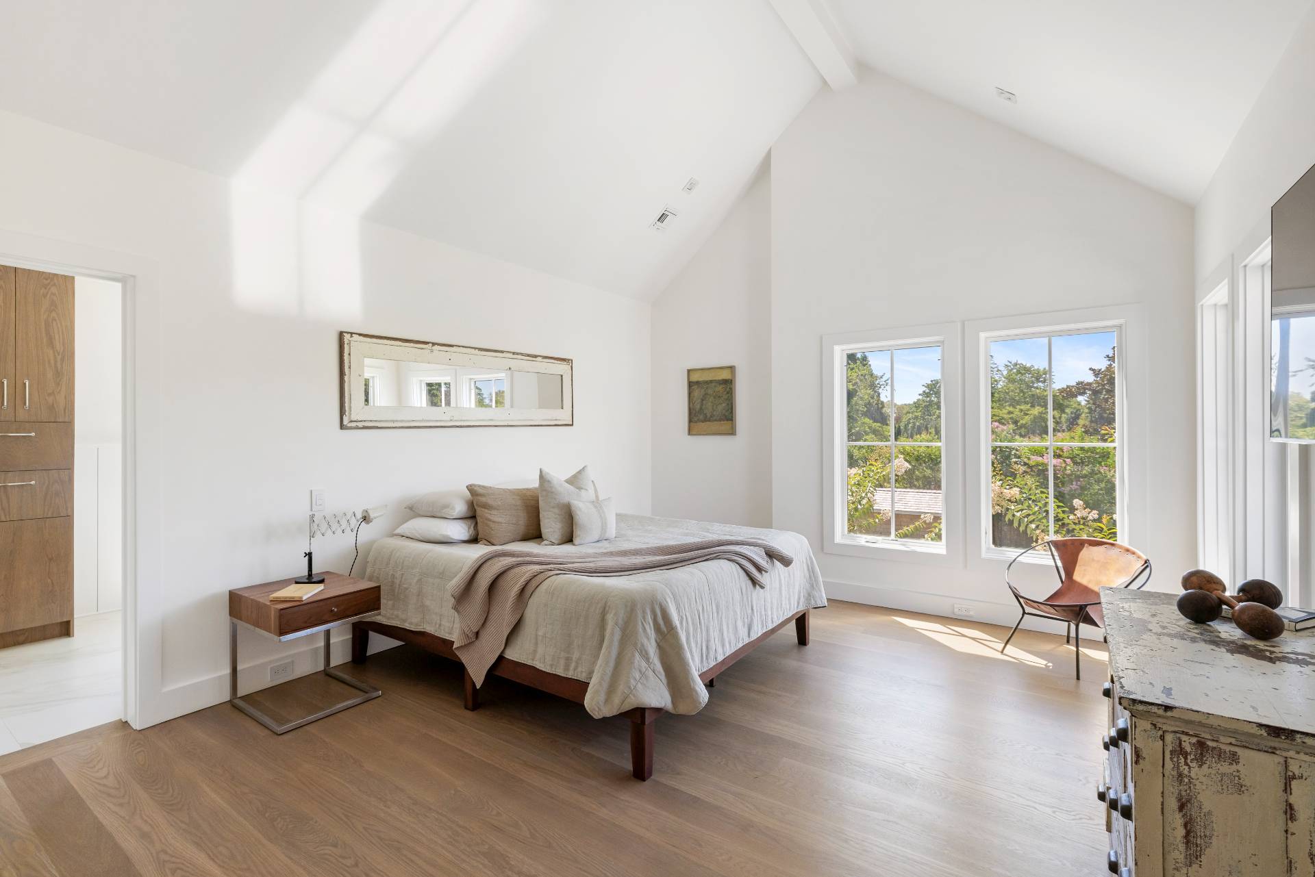 222 White Street Southampton, NY 11968 - Photo 13 of 28 a spacious bedroom with a bed couch and a large window