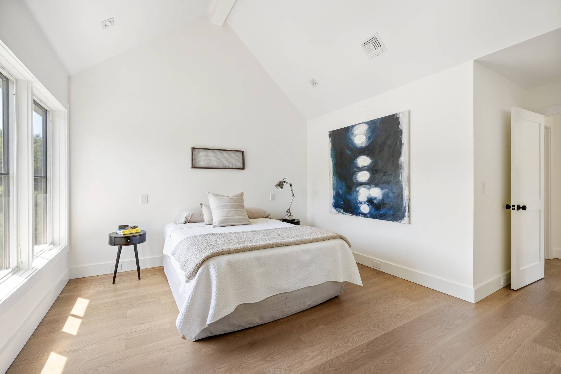 222 White Street Southampton, NY 11968 - Photo 17 of 28 a spacious bedroom with a bed and a painting on the wall