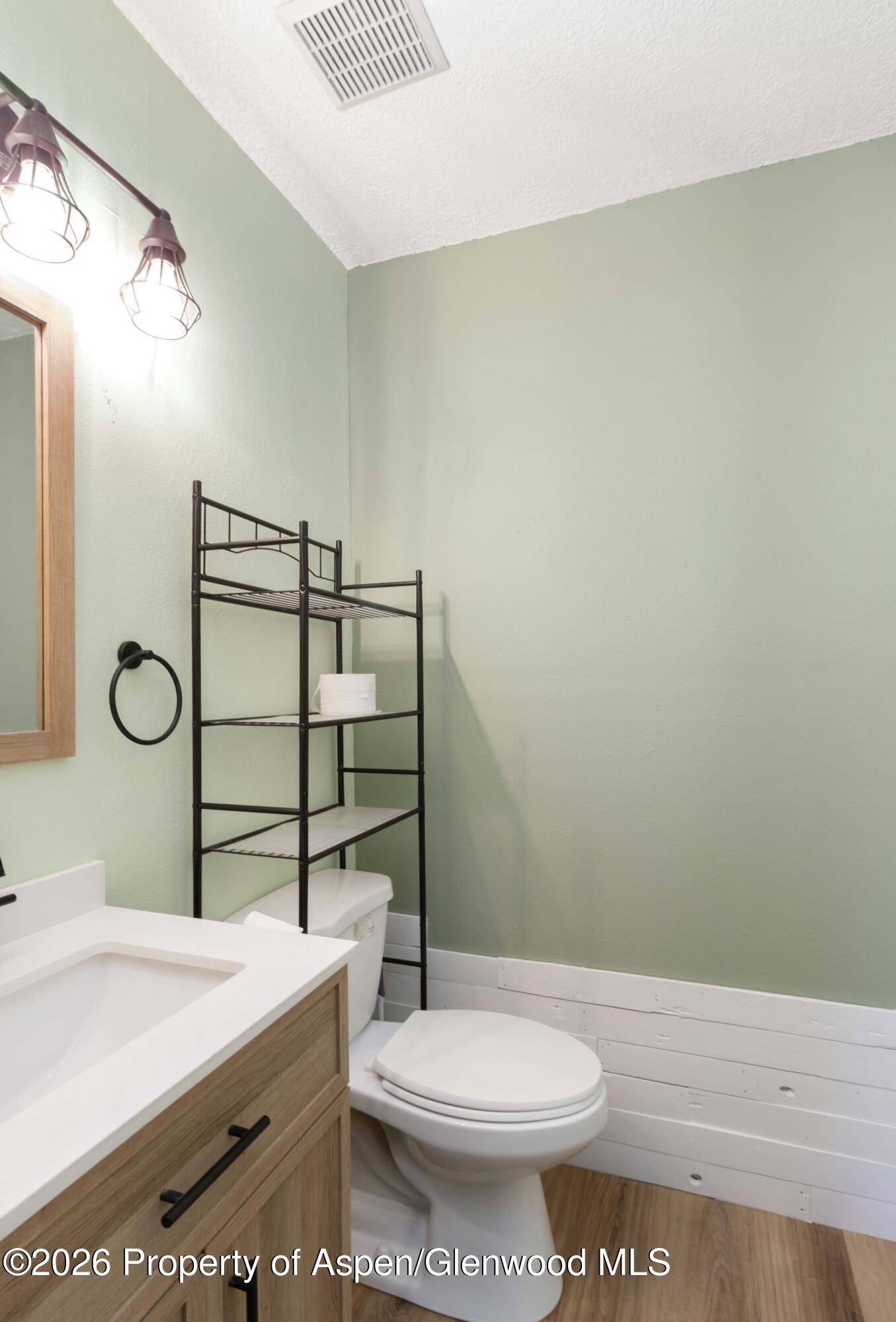 2820 West Avenue Rifle, CO 81650 - Photo 12 of 20 a bathroom with a toilet a sink and mirror