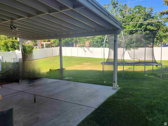 545 100 East Bountiful, UT 84010 - Photo 15 of 17 Fenced backyard with a trampoline and a patio area