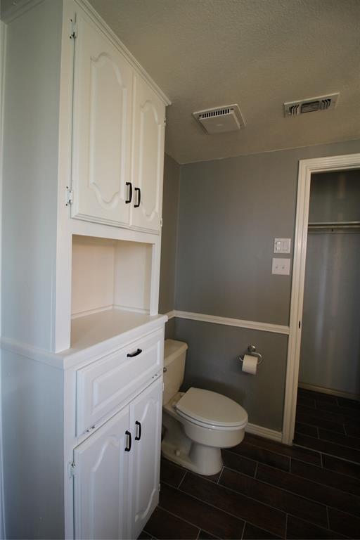 634 Ray Avenue DeSoto, TX 75115 - Photo 11 of 28 Bathroom featuring visible vents, a textured ceiling, wood tiled floor, and toilet
