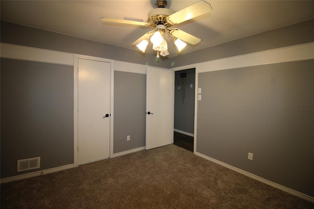 634 Ray Avenue DeSoto, TX 75115 - Photo 14 of 28 Unfurnished bedroom featuring dark carpet, ceiling fan, baseboards, and visible vents