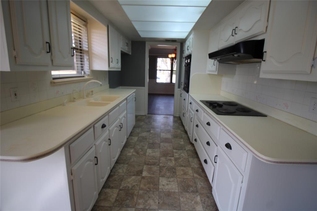 634 Ray Avenue DeSoto, TX 75115 - Photo 22 of 28 Kitchen with black electric cooktop, a sink, white cabinetry, white dishwasher, and under cabinet range hood
