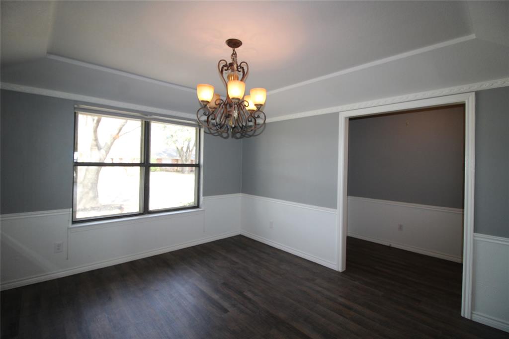 634 Ray Avenue DeSoto, TX 75115 - Photo 6 of 28 Empty room featuring dark wood finished floors, a raised ceiling, and an inviting chandelier