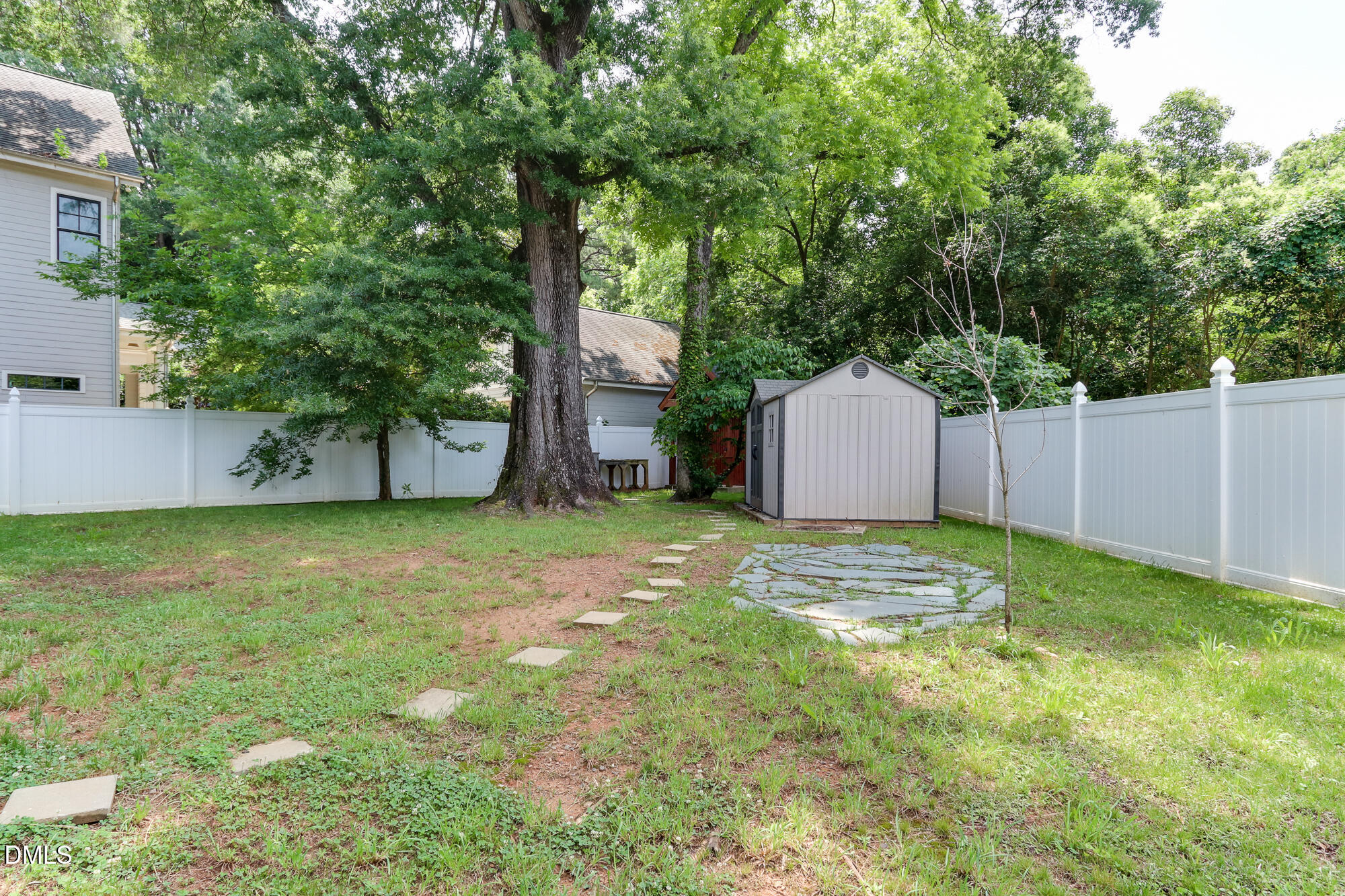 604 Mills Street Raleigh, NC 27608 - Photo 27 of 39 a backyard of a house with a large tree and wooden fence