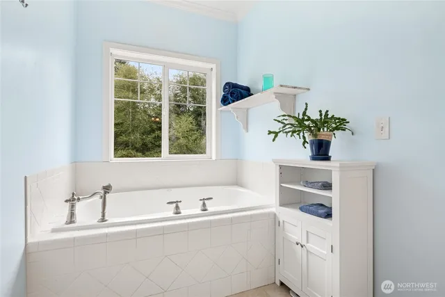 a bathroom with a tub sink and mirror
