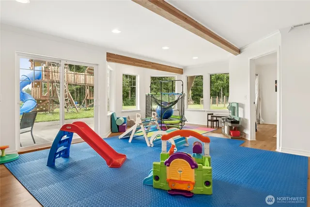 a living room with furniture a rug and a floor to ceiling window