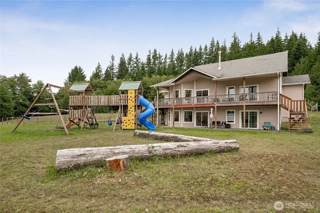 a view of a big house with a big yard and large trees