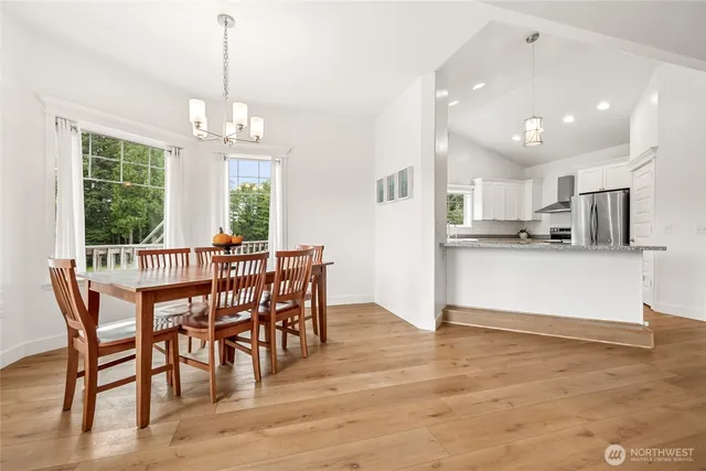 a view of a dining room and livingroom with furniture wooden floor a chandelier