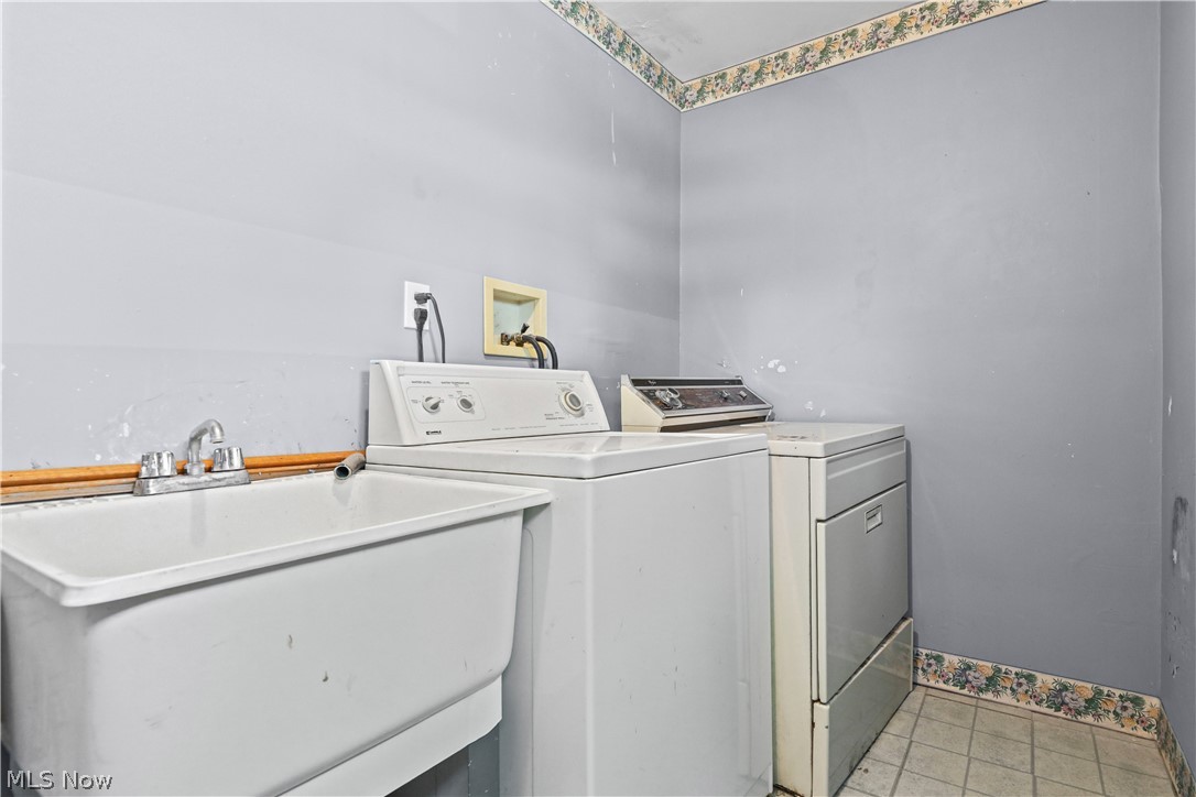 150 Graham Road Cuyahoga Falls, OH 44223 - Photo 23 of 38 Utility sink with chrome faucet and light gray walls featuring a decorative border