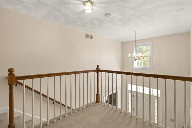 a view of staircase with railing and a chandelier fan