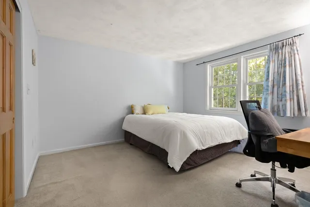 a bedroom with a bed chair and window
