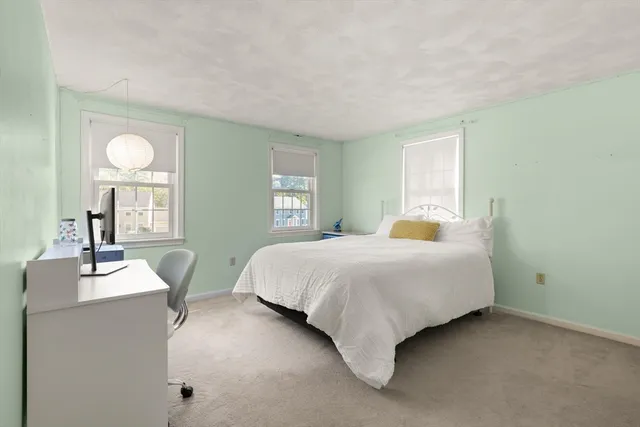 a bedroom with a bed lamps and windows