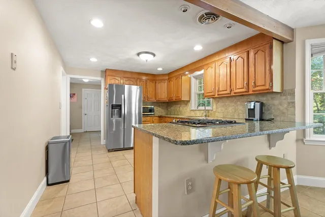 a kitchen with stainless steel appliances granite countertop a refrigerator and a stove top oven