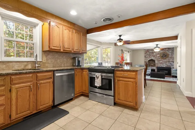 a kitchen with stainless steel appliances granite countertop a stove a sink and a microwave