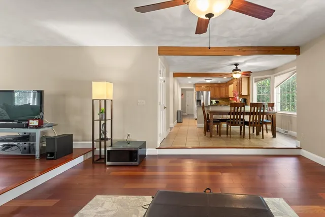 a view of a dining room with furniture a chandelier and wooden floor