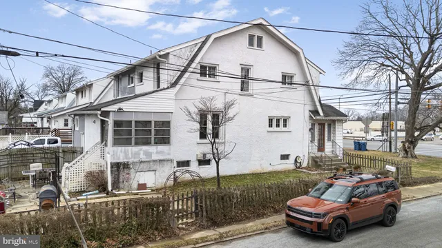 a car parked in front of a white house