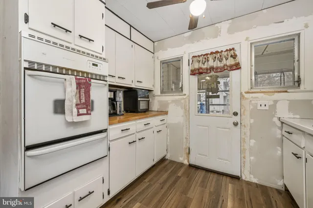 a kitchen with stainless steel appliances white cabinets and wooden floor