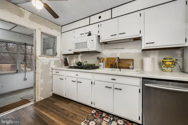 a kitchen with granite countertop white cabinets and white appliances