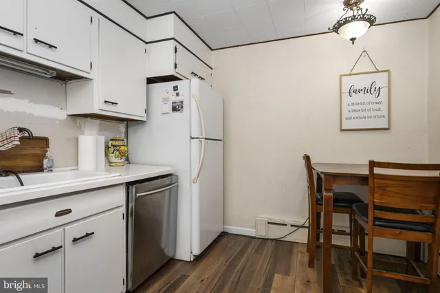 a kitchen with stainless steel appliances a refrigerator and a wooden floor