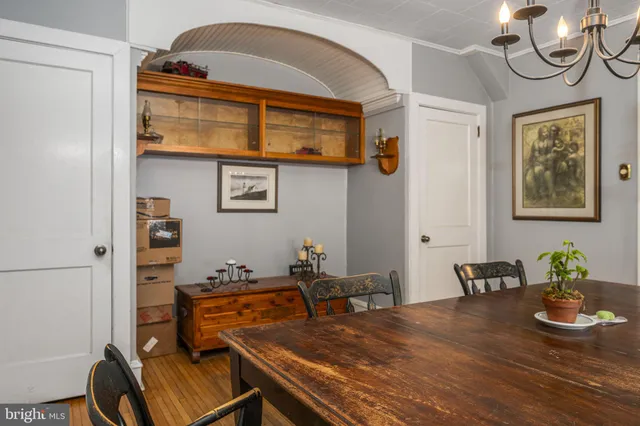 a room with chandelier fan and wooden floor