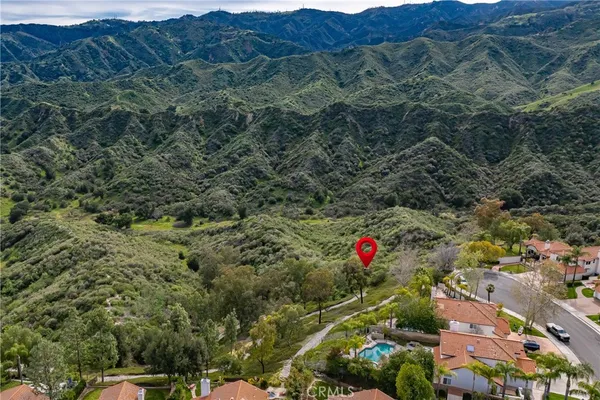 an aerial view of residential houses with outdoor space and trees